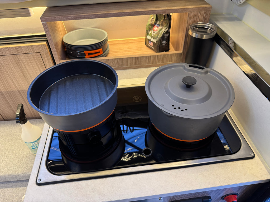 Cooking pots on a stove top with a kitchen setting in the background