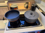 Cooking pots on a stove top with a kitchen setting in the background