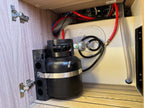 Black cylindrical component with wiring inside a wooden cabinet
