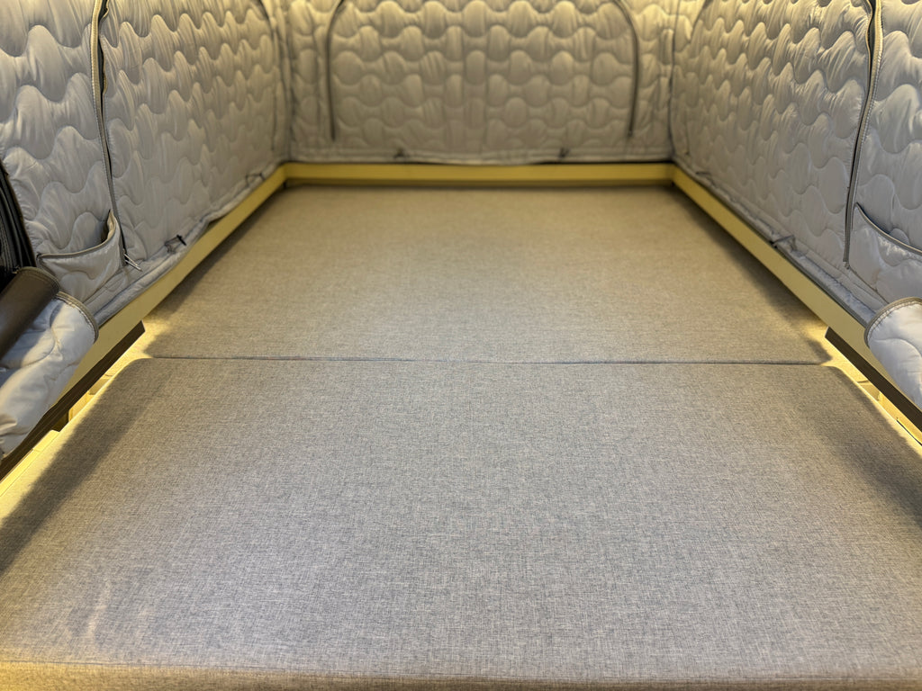 Gray quilted sofa bed with a flat surface
