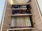 Wooden panel with electrical components and wiring inside a vehicle or RV.